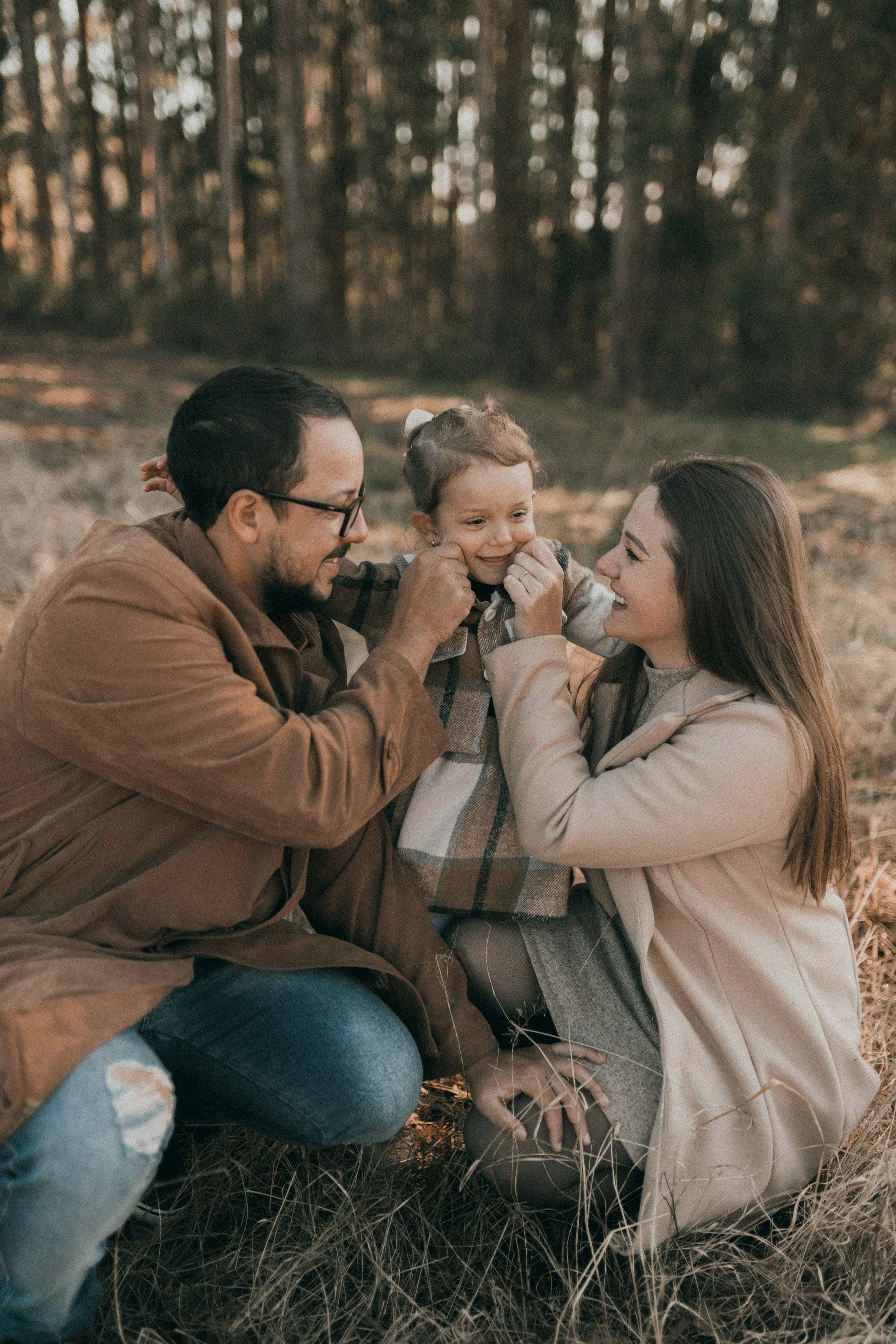 A family sitting close together in an autumn field