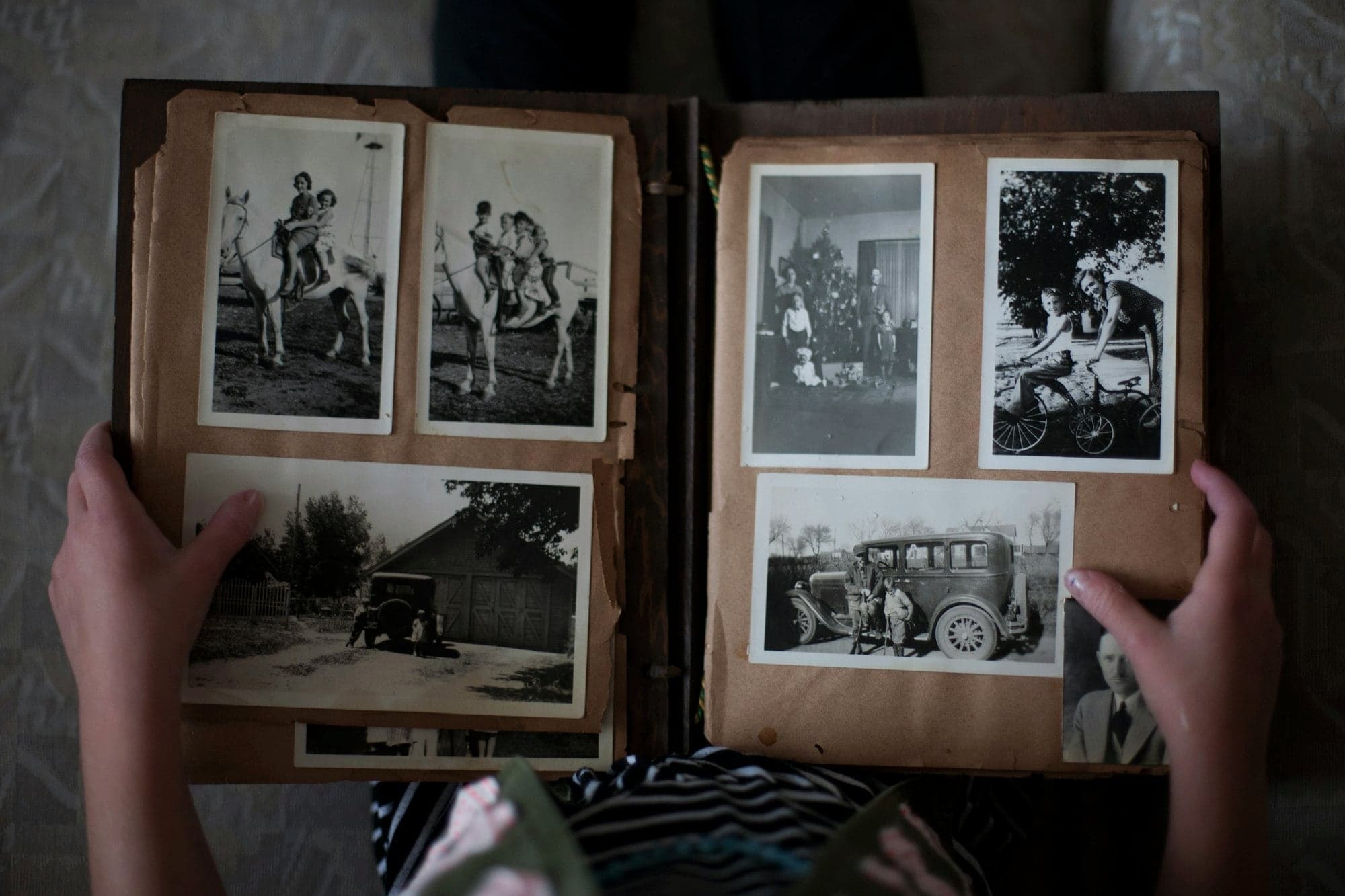 Hands holding open an old family photo album